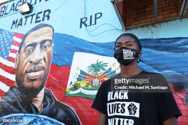 Joshua Griffith looks out towards the street as he awaits the start of a candlelight vigil in celebration of George Floyd's 47th birthday on October...
