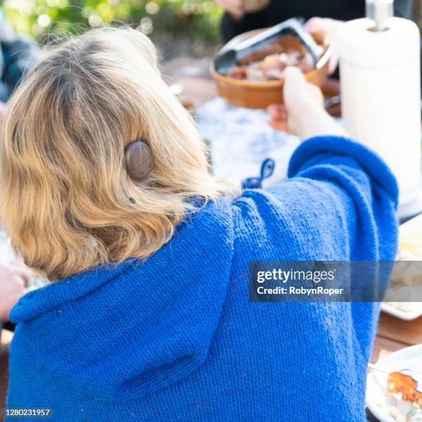 adult female with cochlear implant having pancakes for breakfast outdoors with friends - cochlea implant stock pictures, royalty-free photos & images