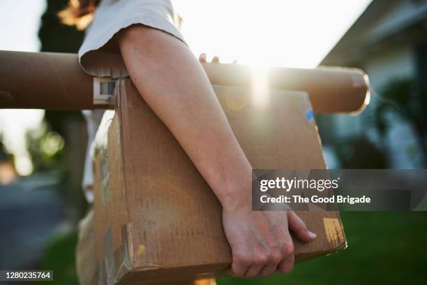 woman delivering packages in residential neighborhood - mailman stock-fotos und bilder