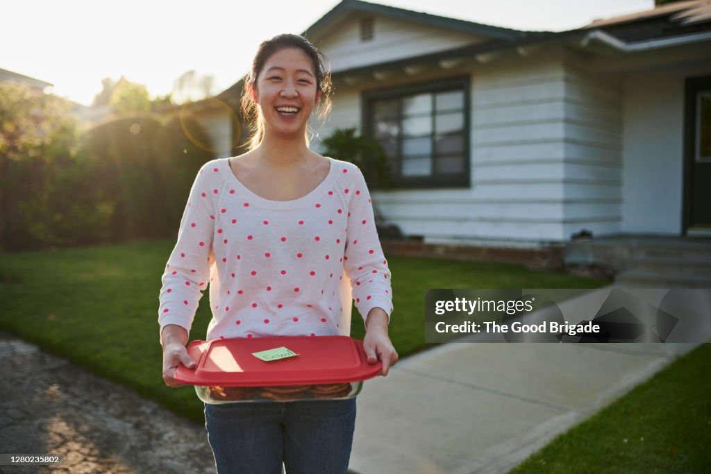 Woman delivering homemade cookies to neighbor