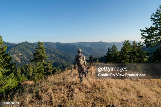 crossbow hunters hiking - archery bow stock pictures, royalty-free photos & images