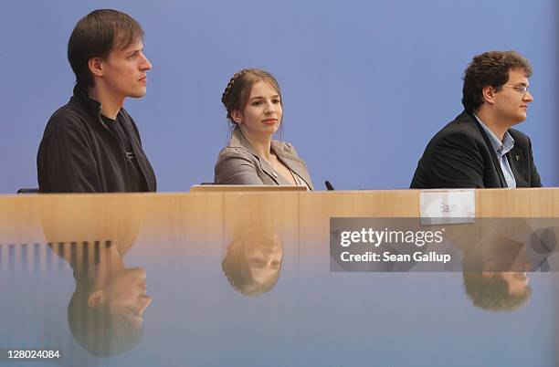 Andreas Baum, Marina Weisband and party Chairman Sebastian Nerz of the Piratenpartei are reflected in glass as they speak to the media during a press...