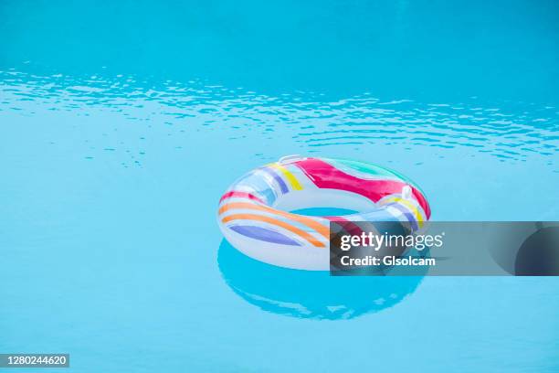 one rainbow inflatable tube float in swimming pool - floating on water stock pictures, royalty-free photos & images