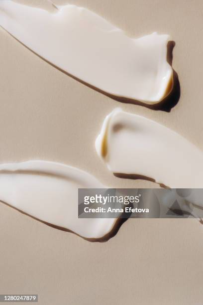 strokes of cream on piece of glass - creme stock-fotos und bilder