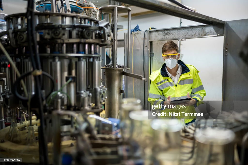 Controller working at Fruit juice Bottle Automated conveyor belt production system. Business and Technology for Food and beverage industry.