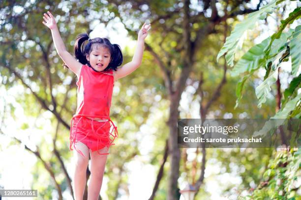 the little boy in red is happy jumping outdoors in the garden. - happy dirty child stockfoto's en -beelden