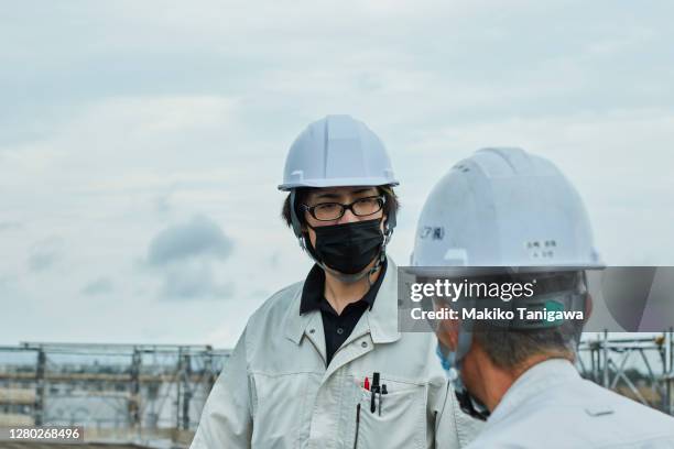 construction workers wearing a protective face mask because covid-19 - 20s talking serious bildbanksfoton och bilder