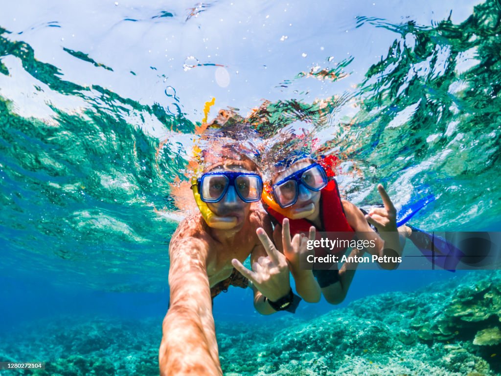 Father and son snorkeling near the coral reef. Vacation at sea