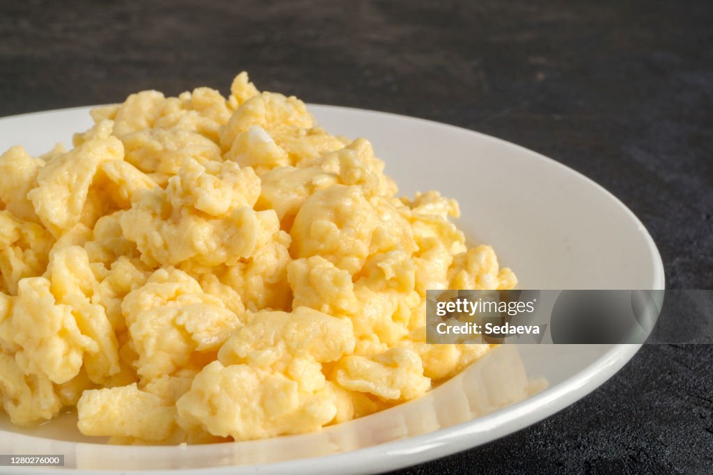 Scrambled eggs on a white plate.
