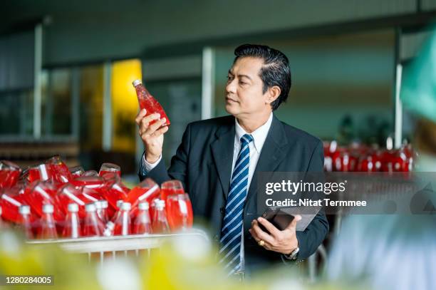 business owner giving plant tour of the basil seed mixed fruit flavors drink production facility. food and beverage industry business. - food and drink industry stockfoto's en -beelden