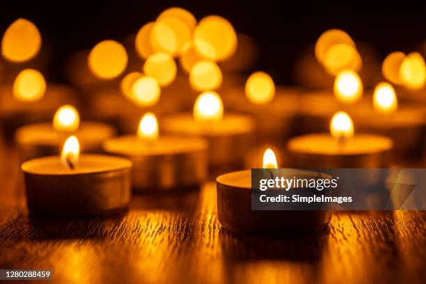 golden lights of burning candles in a christmas atmosphere. spa wellness religious and spirituality concept. - candela foto e immagini stock