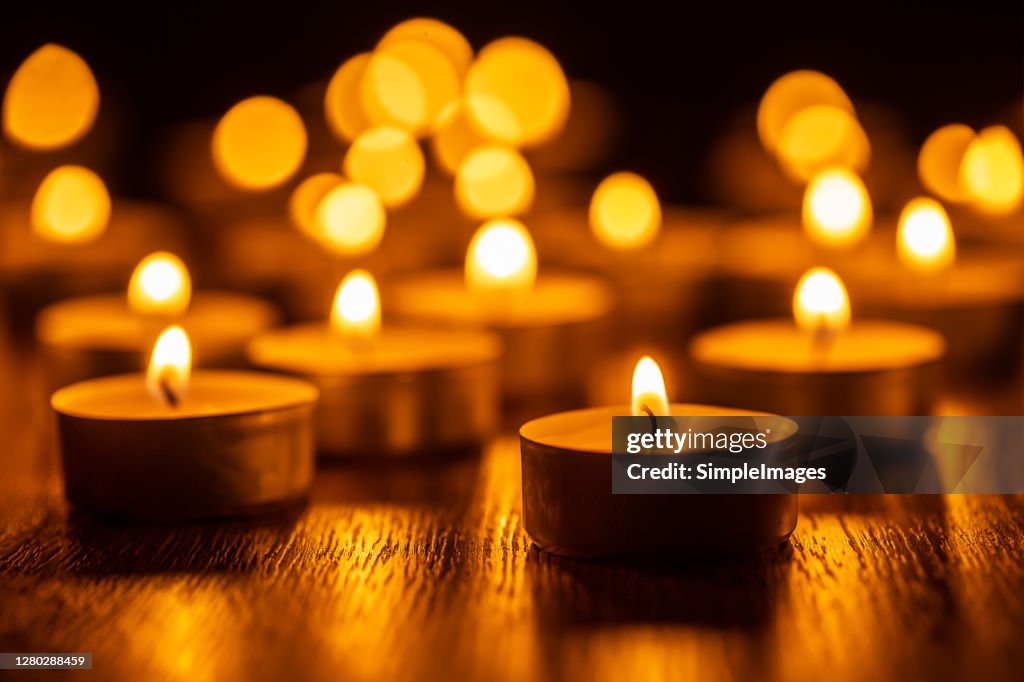 Golden lights of burning candles in a Christmas atmosphere. Spa wellness religious and spirituality concept.