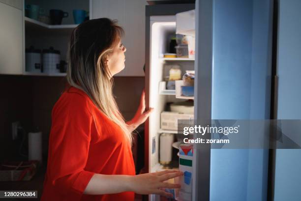 schwangere frau vor dem offenen kühlschrank mitten in der nacht - open fridge stock-fotos und bilder