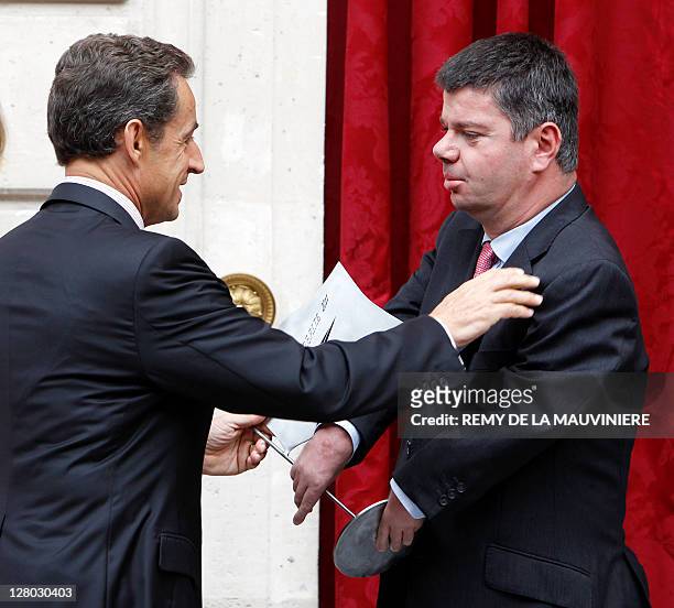 French President Nicolas Sarkozy offers a gift to Ludovic Bejot President of the 'Mission Bleu Ciel' which is offered for Paolo Pocobelli, a test...