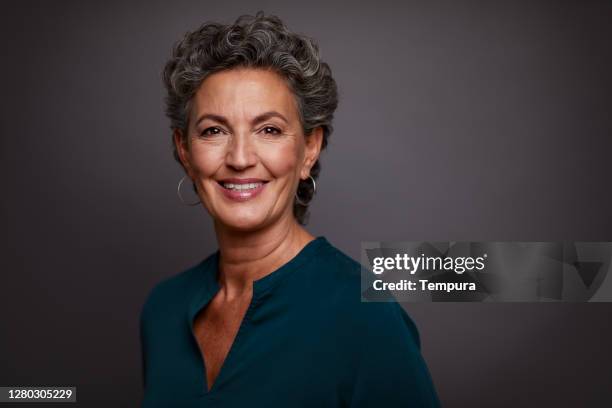 studio portrait of a beautiful middle-aged woman looking at the camera. - older woman short hair stock pictures, royalty-free photos & images