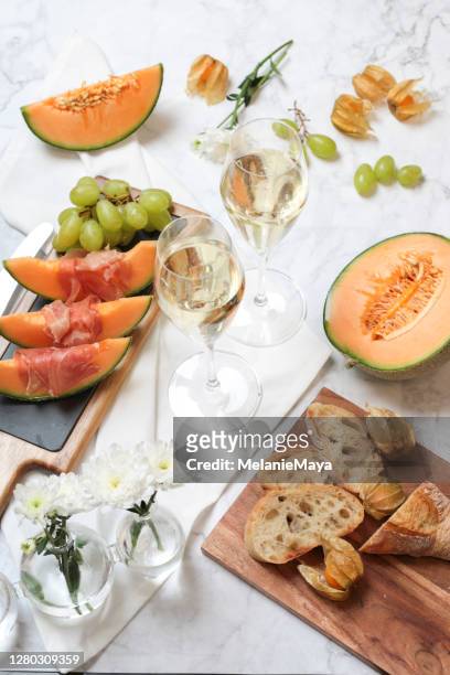 food flatlay with melon and prosciutto ham appetizer with wine - prosecco stock pictures, royalty-free photos & images
