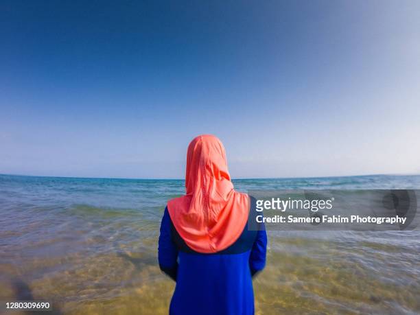 rear view of a muslim woman wearing a burkini on a beach - 回教泳裝 個照片及圖片檔
