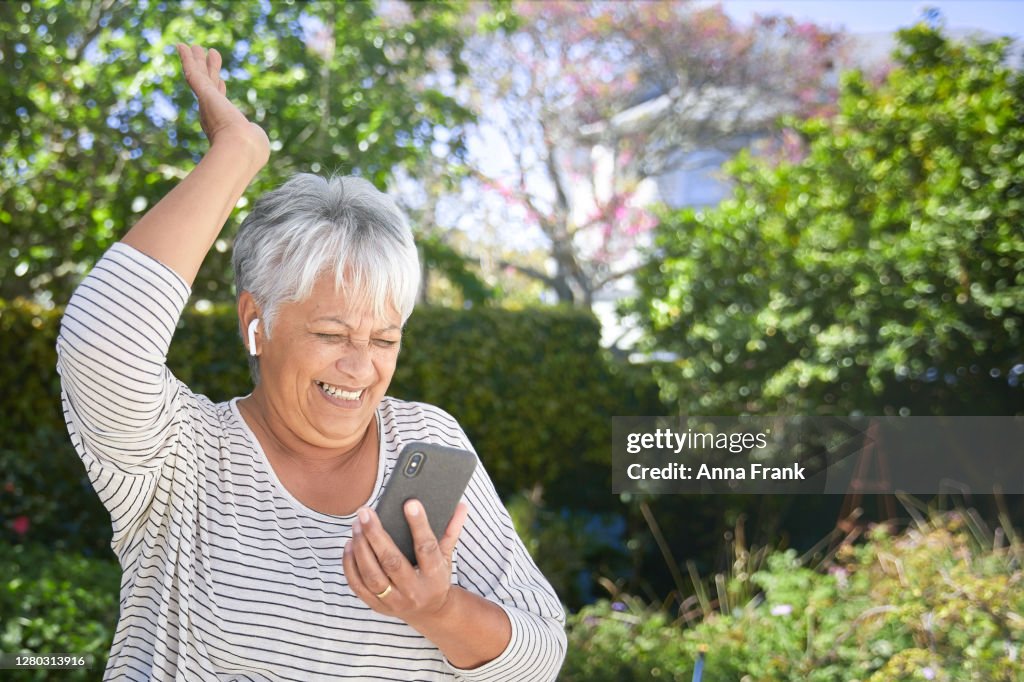 Happy senior woman dancing in her garden