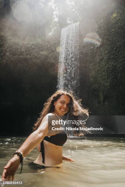 woman in front of the beautiful waterfall in ubud, bali - bali waterfall stock pictures, royalty-free photos & images