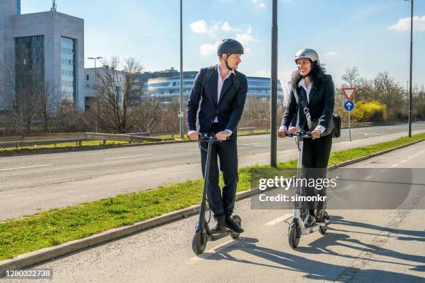 business people riding electric scooters - electric push scooter stock pictures, royalty-free photos & images
