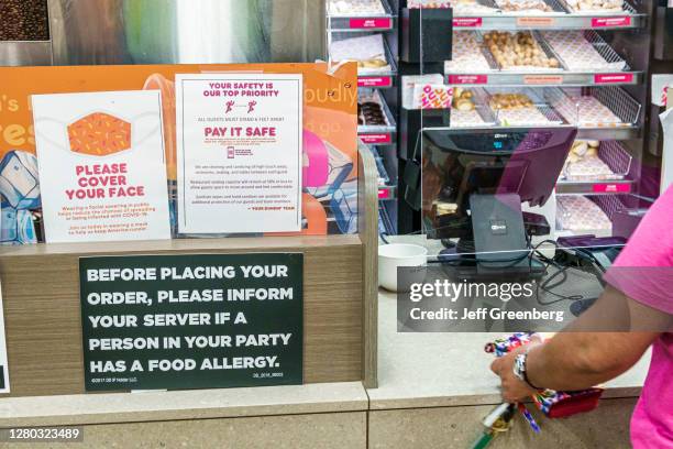 Florida, Dunkin' Donuts, coffee shop with safety guideline signs, and food allergy warning.