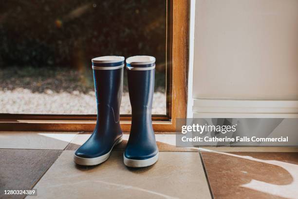 blue welly boots sitting by an open back door. - wellington boot stock pictures, royalty-free photos & images