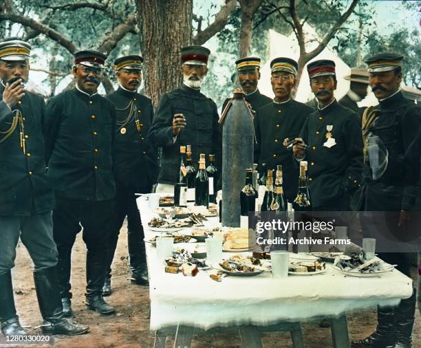 Colorized photo of Japanese General Count Nogi Maresuke and officers standing around a table during a victory celebration during the Russo-Japanese...