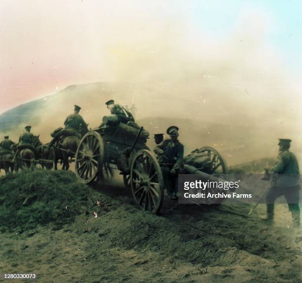 Colorized photo of Russian soldiers on horseback as they pull a cannon on wheels along a dirt path during the Russo-Japanese War, 1905.