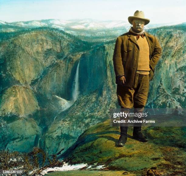 Colorized portrait of American politician and US President Theodore 'Teddy' Roosevelt Jr posing on Overhanging Rock at the top of Glacier Point with...