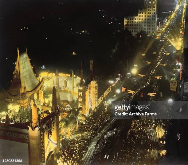 Colorized, high-angle view of illuminated Grauman's Chinese Theatre and Hollywood Boulevard, crowded with fans, during the premiere of the film,...