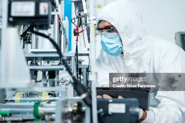 production and process control, quality control management system concepts. technician working at automated production line in medical face mask factory. - 製品　実験 ストックフォトと画像