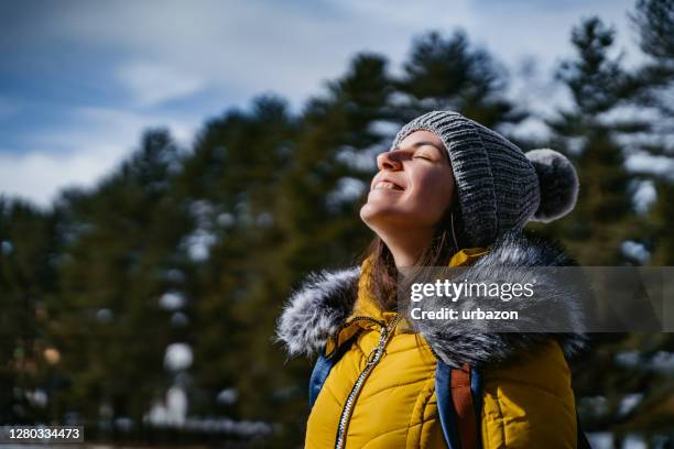 woman absorb sunlight in winter - warm jacket stock pictures, royalty-free photos & images