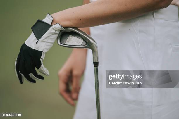close up asian chinese female golfer's hamd on golf club - golf tournament stock pictures, royalty-free photos & images