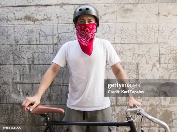 a young southeast asian man in red bandana face mask outdoor with road bike - bandana stock pictures, royalty-free photos & images