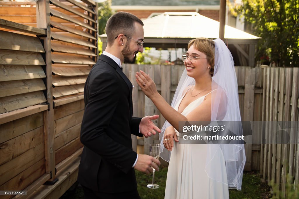 Millennial frisch vermählte paar posiert bei Hochzeit Cocktail im Hinterhof.