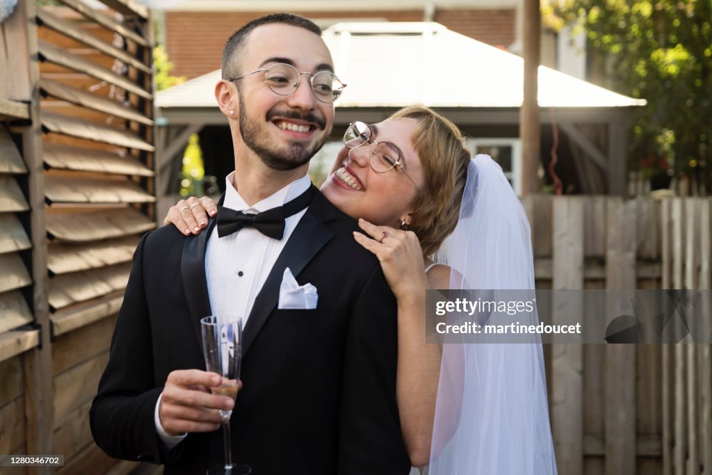 Couples de jeunes mariés millénaires posant au cocktail de mariage dans l’arrière-cour.