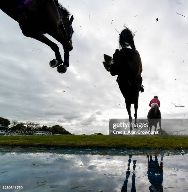 Ben Poste riding Dollar And A Dream clear the water jump on their way to winning The Use The racingtv.com Tracker Novices' Handicap Chase at...