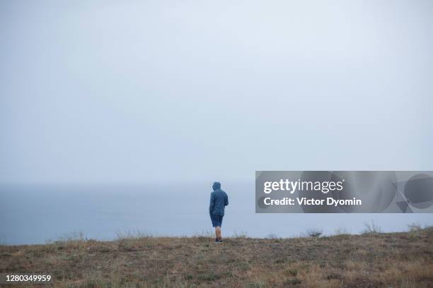 lonely man on the cold sea shore - zelfmoord stockfoto's en -beelden