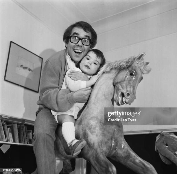 Scottish comedian Ronnie Corbett on a rocking horse with his daughter, Sophie, January 1969.