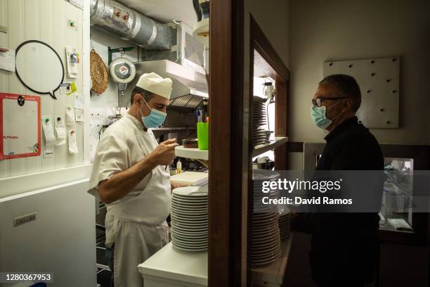 Gerardo Hervella and Sindo Gonzalez works in the kitchen during the midday service of the last of day of opening for the Envalira Restaurant before...