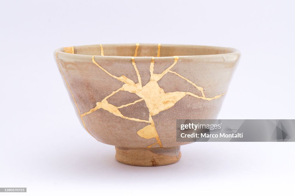 Antique broken Japanese beige bowl repaired with gold kintsugi technique