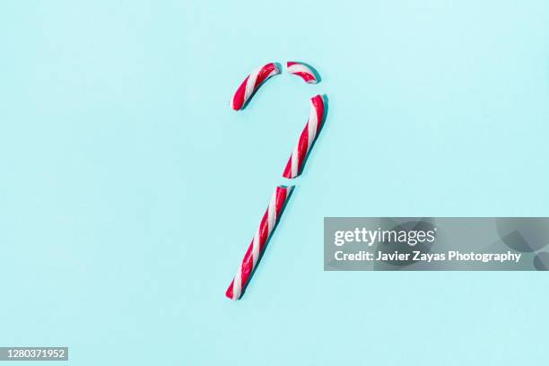 broken christmas candy cane an a turquoise background - broken christmas bauble stock pictures, royalty-free photos & images