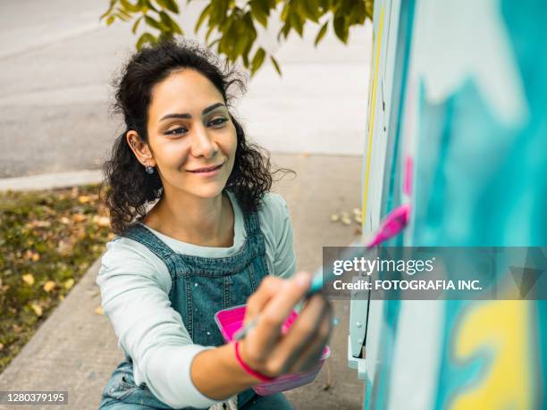 artista mural femenina en el trabajo - murales fotografías e imágenes de stock