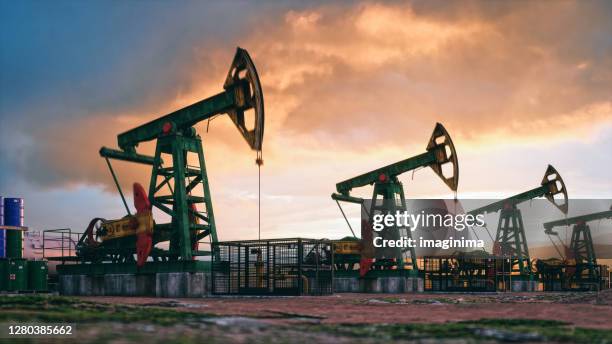 pumpjacks de trabajo al atardecer - pozo de petróleo fotografías e imágenes de stock