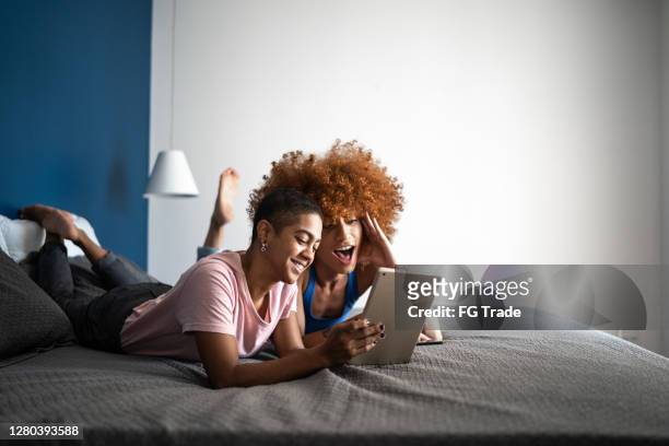 feliz pareja usando tableta digital en la cama en casa - lovers 2020 film fotografías e imágenes de stock