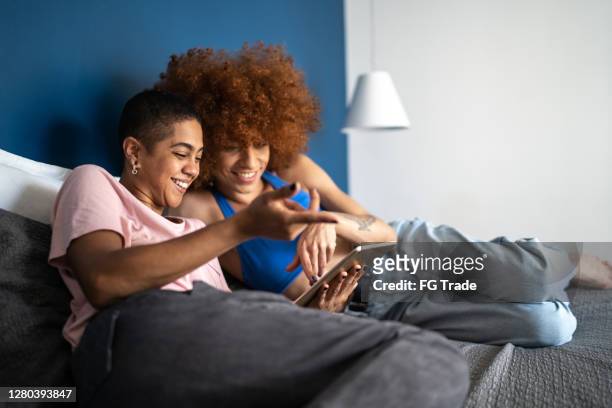 gelukkig paar dat digitale tablet in bed thuis gebruikt - movie meets media stockfoto's en -beelden