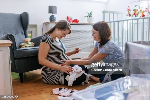 woman feeling movements of baby fresh in nursery room. - prenatal care stock pictures, royalty-free photos & images