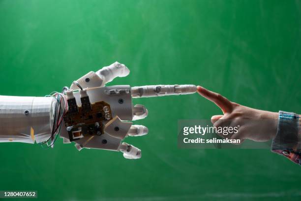 human finger touches robotic finger - robot hand human hand stock pictures, royalty-free photos & images