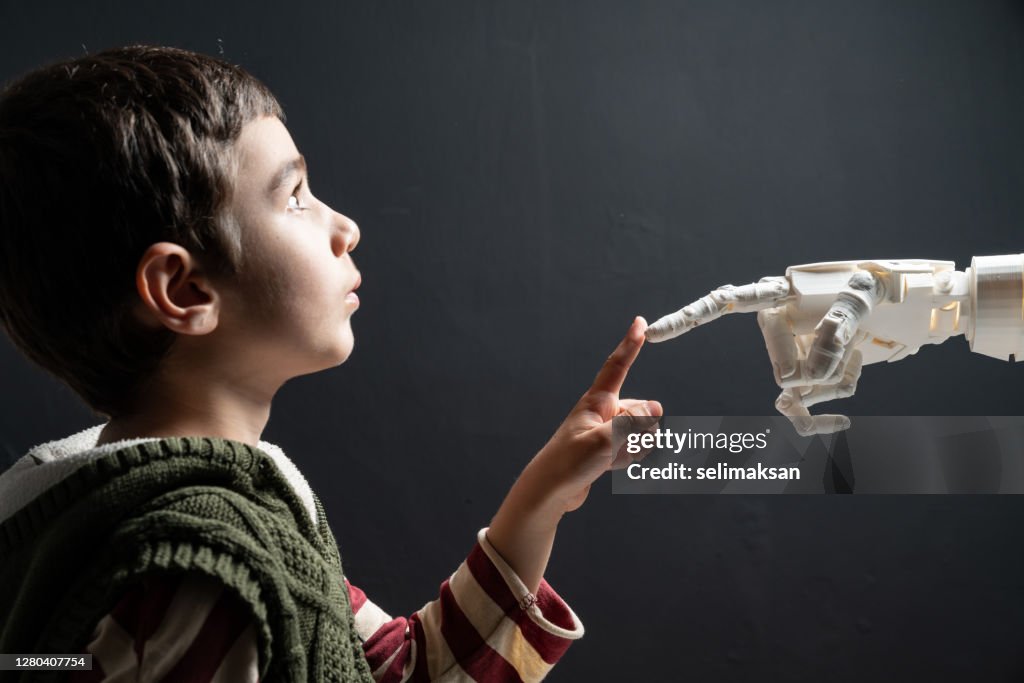 Grundschuljunge berühren Deichroboter Hand