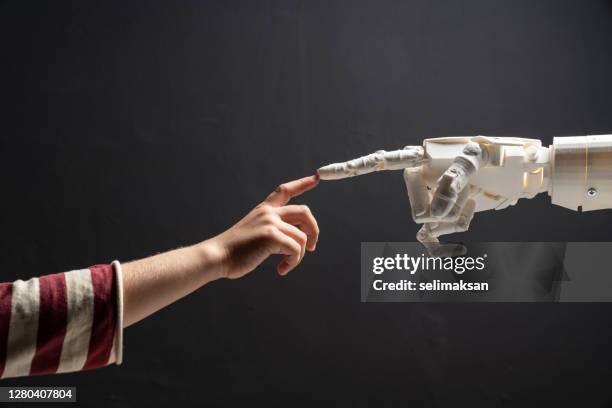 human finger touches robotic finger - child reaching stock pictures, royalty-free photos & images